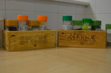 Two wooden open boxes next to each other with and herb and spice written on them.