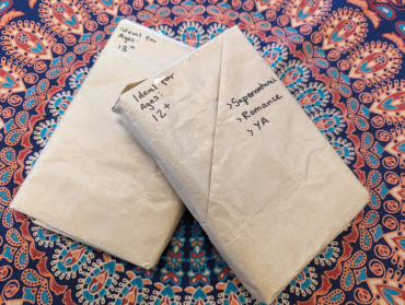 Two books, wrapped in brown paper - each with a short description of the age range and key features of the book