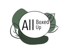 The logo for "All Boxed Up" features the brand name in black text within a white oval, surrounded by green leaf drawings and shapes.