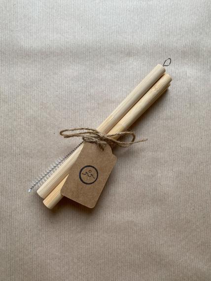4 large bamboo straws and a cleaning brush tied together with string and a label