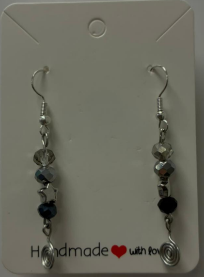 a silver hook earing with grey bead, black bead and a silver star with a darker black bead with a black metal spiral at the bottom